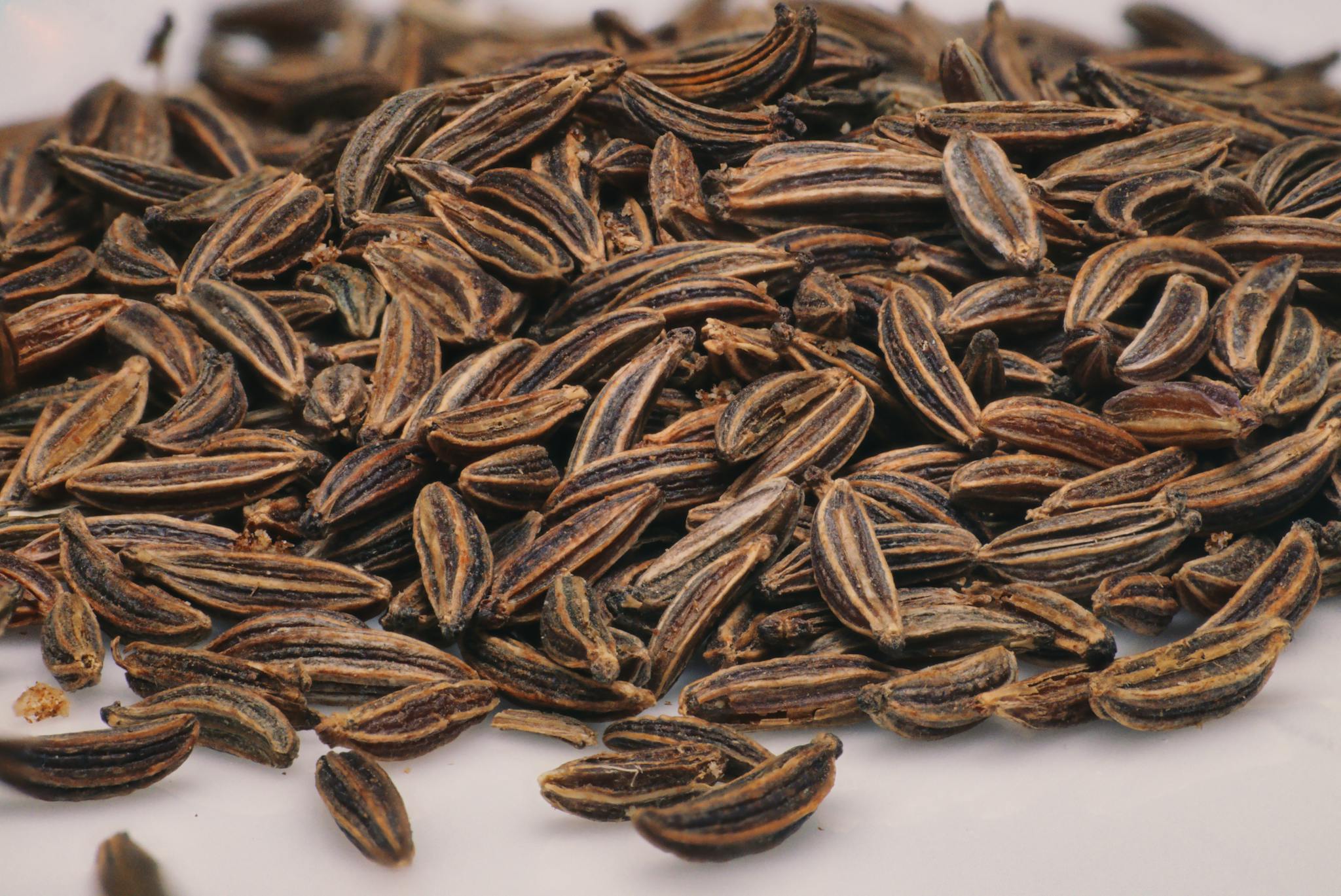 Detailed close-up of aromatic caraway seeds, perfect for culinary use, captured in a kitchen environment.