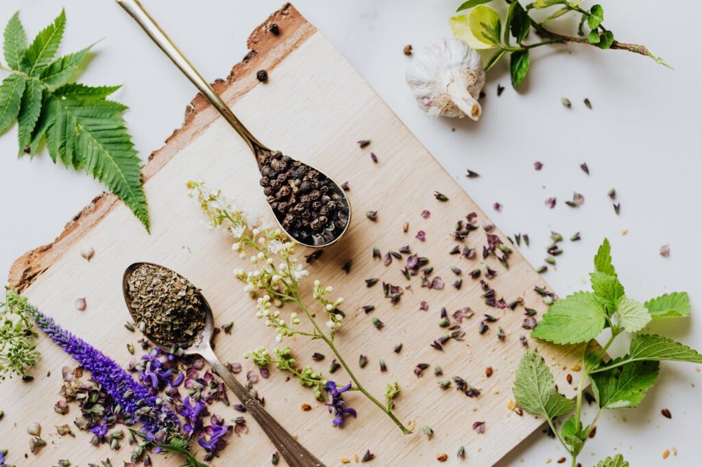 A top view of dried and fresh herbs on a wooden board, perfect for culinary and medicinal uses.